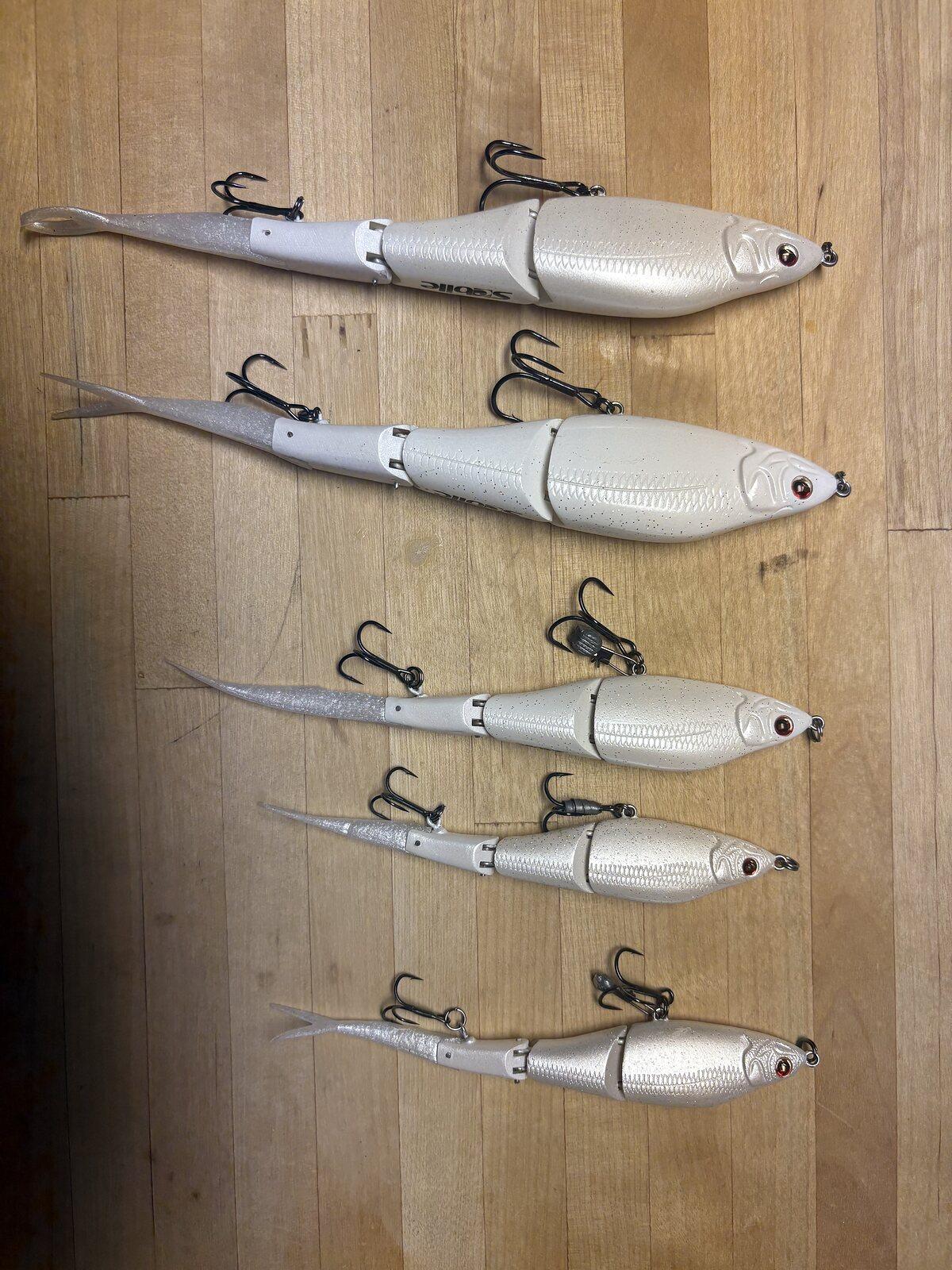 White Cabretta baits rigged with hooks, lined up on a wooden bench